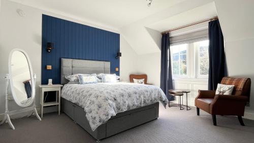 a bedroom with a bed and a mirror and a chair at Lochinver Manse in Lochinver
