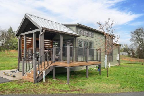 a tiny house with a porch and a deck at Pigeon Forge Landing RV Resort in Pigeon Forge