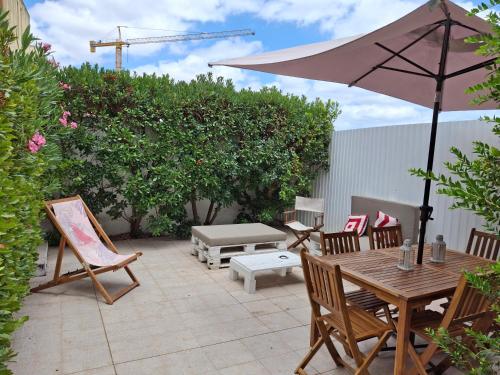 a patio with a table and chairs and an umbrella at Travessa Houses in Lisbon