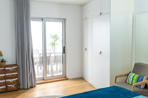 a bedroom with a bed and a large window at Sesimbra Ocean Terrace in Sesimbra
