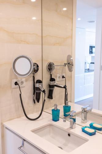 a bathroom sink with a blow dryer and a mirror at Sesimbra Ocean Terrace in Sesimbra