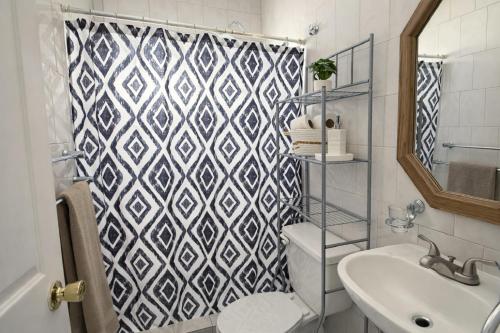 a bathroom with a black and white patterned shower curtain at Casa Real in Manuel F. Martínez