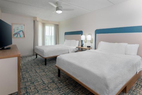 a hotel room with two beds and a flat screen tv at Homewood Suites by Hilton Orlando-Nearest to Universal Studios in Orlando