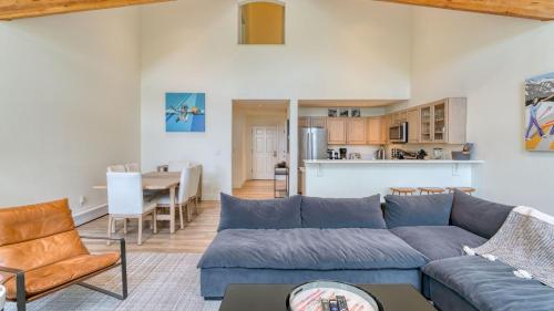 a living room with a blue couch and a table at Emerald Elk at Village Creek by AvantStay Close to Slopes Village w Views in Telluride