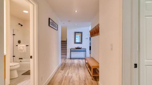 a hallway with a bathroom with a toilet and a sink at Emerald Elk at Village Creek by AvantStay Close to Slopes Village w Views in Telluride