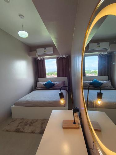 a bedroom with a mirror and a bed and a table at Tahanan in Iloilo City