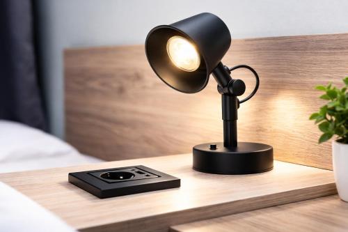 a black desk lamp on a bedside table at NIVAN Hostel in Hamburg
