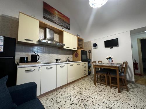 a kitchen with white cabinets and a table with a dining room at Lost In Amalfi in Amalfi