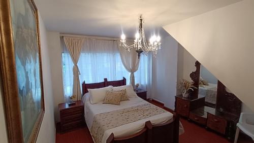 a bedroom with a bed with a chandelier and a window at Apartamento amoblado a excelente precio in Bogotá