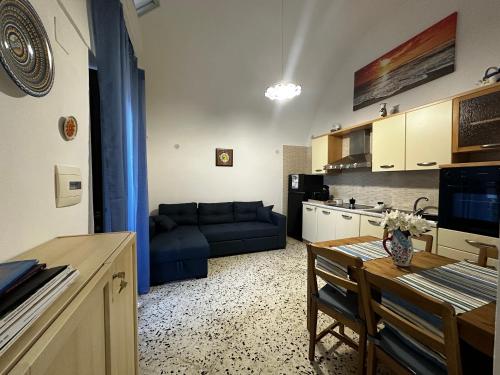 a living room with a blue couch and a table at Lost In Amalfi in Amalfi