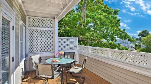 a patio with a table and chairs on a balcony at Duval Breeze by AvantStay Great Location Close to Beach Nightlife Shared Pool Week Long Stays in Key West