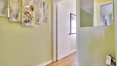 a hallway with green walls and a white door at Duval Breeze by AvantStay Great Location Close to Beach Nightlife Shared Pool Week Long Stays in Key West