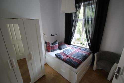 een slaapkamer met een raam en een bed met kussens bij LE-Citywohnung-I in Leipzig