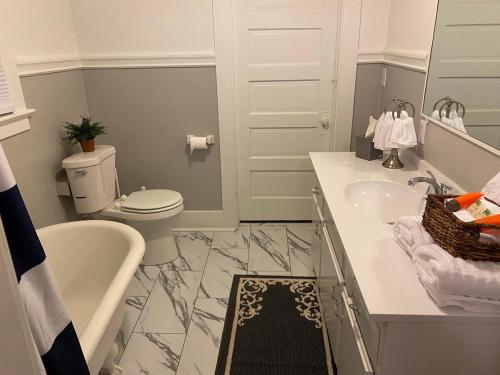 a bathroom with a toilet and a sink and a tub at Classic California Bungalow Downtown in Bakersfield