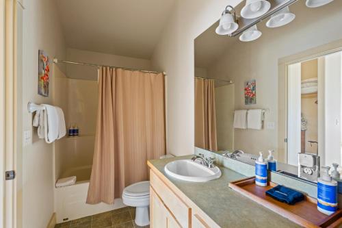 a bathroom with a sink and a toilet and a mirror at Big Mountain View Condo in Sisters