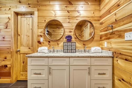 a bathroom with two sinks and two mirrors at Leconte Mountain Lodge in Sevierville