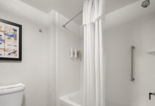 a white bathroom with a shower and a toilet at Homewood Suites by Hilton Boston Brookline-Longwood Medical in Brookline