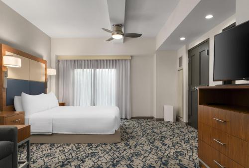 a hotel room with a bed and a flat screen tv at Homewood Suites by Hilton Boston Brookline-Longwood Medical in Brookline
