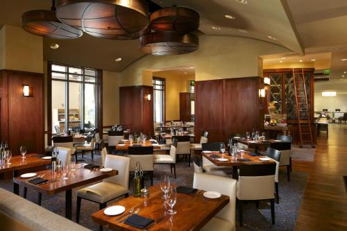 a dining room with wooden tables and chairs and a restaurant at Hilton Grand Vacations Club Las Palmeras Orlando in Orlando