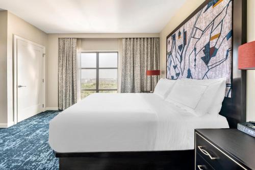 a large white bed in a room with a window at Hilton Grand Vacations Club Las Palmeras Orlando in Orlando