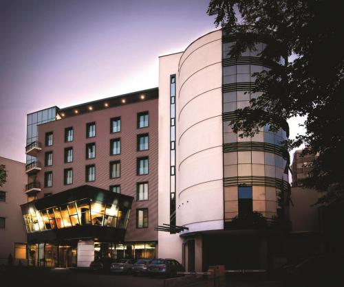 a tall building with a building at DoubleTree by Hilton Hotel Cluj - City Plaza in Cluj-Napoca