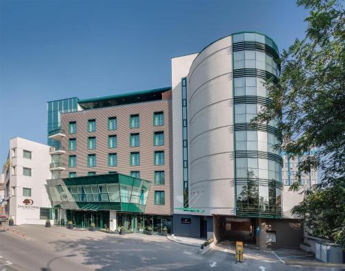 an office building with a round building at DoubleTree by Hilton Hotel Cluj - City Plaza in Cluj-Napoca