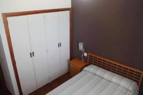 a bedroom with a bed and two cupboards and a bed sidx sidx sidx sidx at Apartamentos El Puerto in Alcossebre