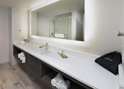 a bathroom with a sink and a mirror at The Island House Hotel a Doubletree by Hilton in Orange Beach