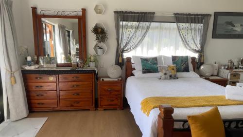 a bedroom with a bed and a dresser and a mirror at Mels Retreat in Te Kuiti