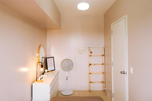 a room with a desk with a fan and a mirror at Tahanan in Iloilo City