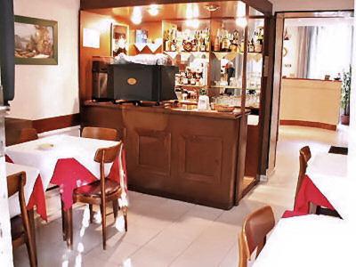 un restaurante con un bar con mesas y sillas en Hotel Rallye, en Milán