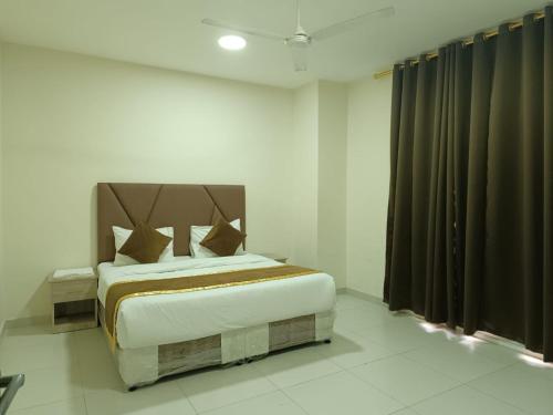 a bedroom with a large bed with brown curtains at قولد شير 2 in Salalah