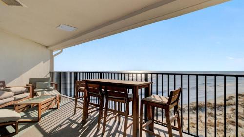 a balcony with a table and chairs and the ocean at 513 Seascape by AvantStay Oceanfront Home w Amazing Views Community Pool Access in Isle of Palms