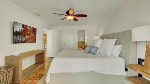 a bedroom with a white bed with a ceiling fan at 513 Seascape by AvantStay Oceanfront Home w Amazing Views Community Pool Access in Isle of Palms