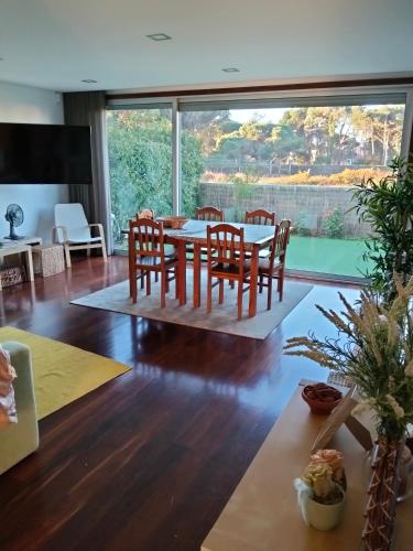 a living room with a table and chairs and a large window at Sunny Ofir in Fão