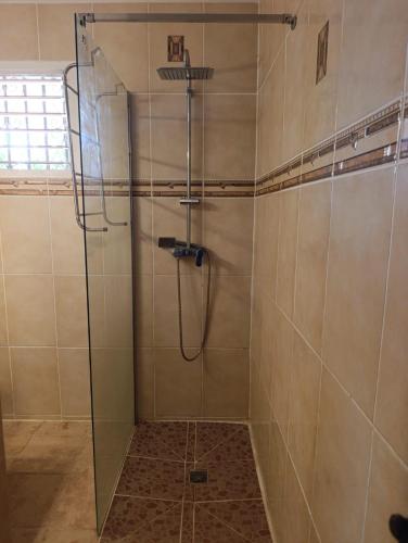 a shower with a glass door in a bathroom at Villa Renée in Petit-Bourg
