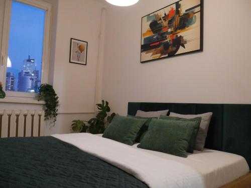a bedroom with a bed with green sheets and a window at Spacious 3 room apartment in center perfect for family or a group of friends in Warsaw