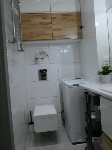 a white bathroom with a toilet and a sink at Spacious 3 room apartment in center perfect for family or a group of friends in Warsaw