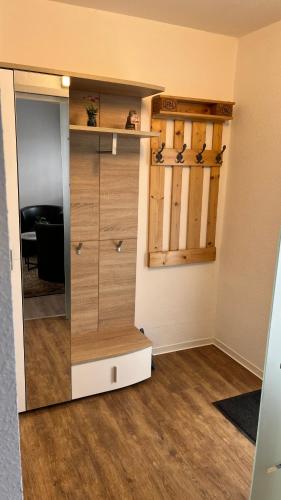 a closet with wooden cabinets and a mirror at Ferienwohnung Safran 2 in Konz