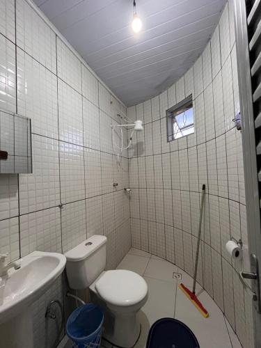 a white bathroom with a toilet and a sink at Suítes FM in Cavalcante