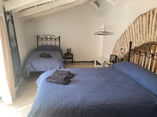 a bedroom with two beds with blue comforter at Moreria Suites in Constantina