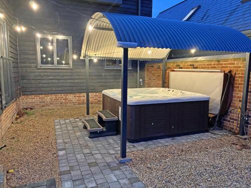a hot tub with a blue cover in a backyard at Lime Tree House - Uk49477 in Bulmer