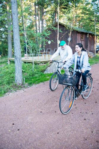 two men riding bikes down a dirt road at Villa Kommodor in Lumparland