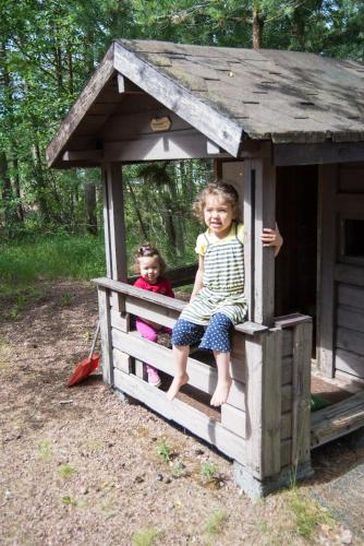 two children are sitting in a play house at Villa Kommodor in Lumparland