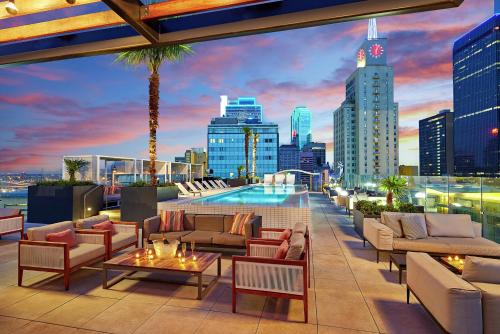 a rooftop patio with furniture and a city skyline at The Statler Dallas, Curio Collection By Hilton in Dallas