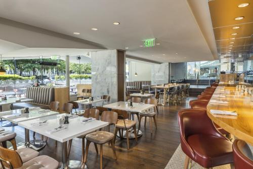 a restaurant with tables and chairs and a bar at The Statler Dallas, Curio Collection By Hilton in Dallas