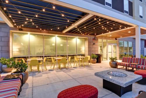 a patio with tables and chairs in a building at Home2 Suites By Hilton Tampa USF Near Busch Gardens in Tampa
