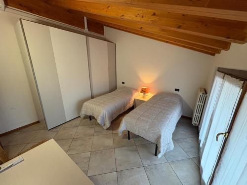 a room with two beds and a table with a lamp at Hub 2A in Calcio