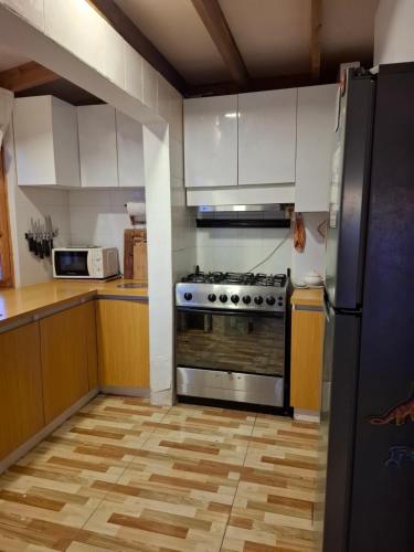 a kitchen with a stainless steel stove and white cabinets at Casa de playa con espectacular vista in Islote Ramadas