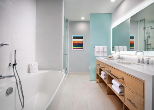 a white bathroom with a tub and a sink at Hotel del Coronado, Curio Collection by Hilton in San Diego